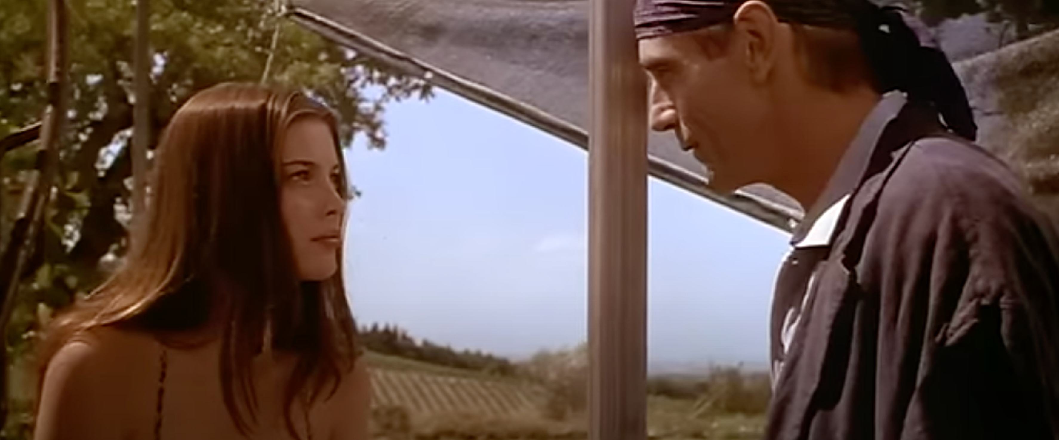Liv Tyler and Jeremy Irons in serious conversation outdoors in a scene from "Stealing Beauty"
