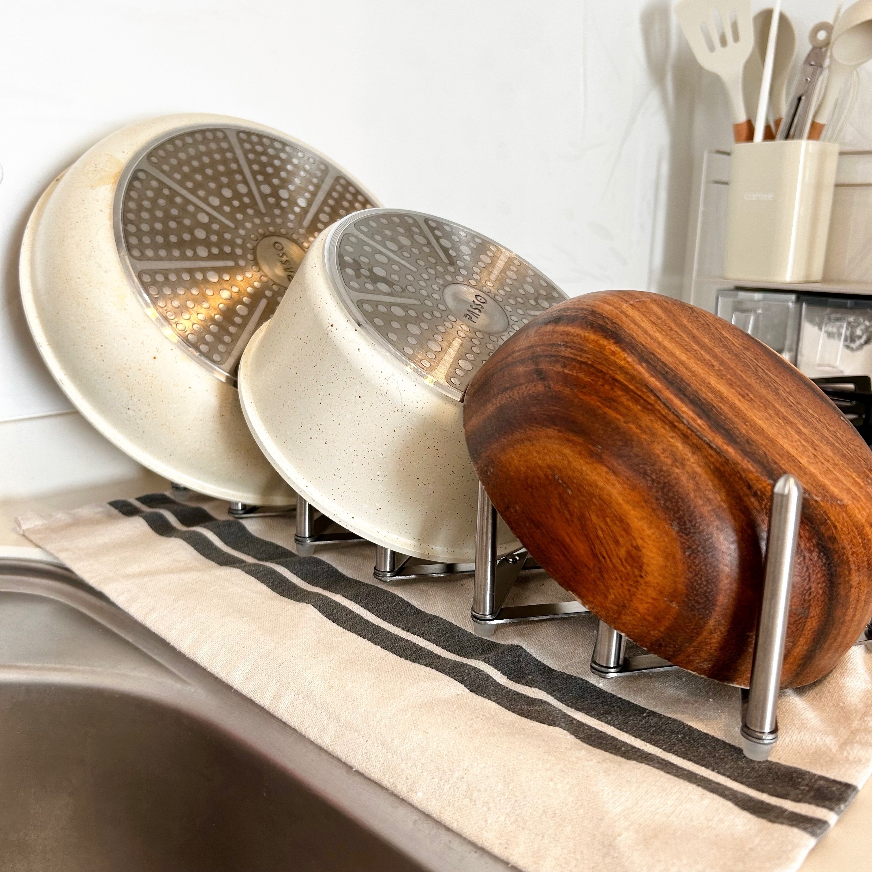 キッチンに置かれたお皿立てに、3つの鍋が立てられている。鍋の底が見えるデザイン。