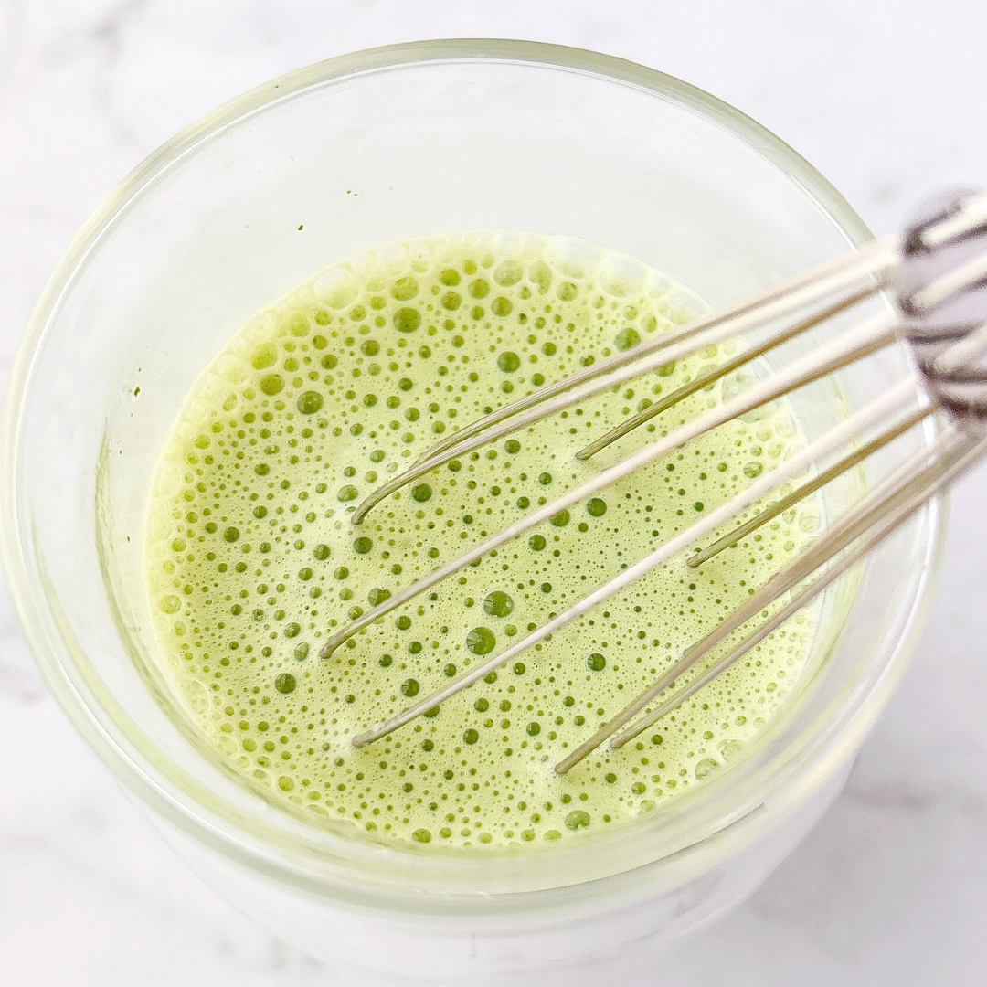 泡立て器が入ったグラスには泡立てられた緑茶ラテが入っています。