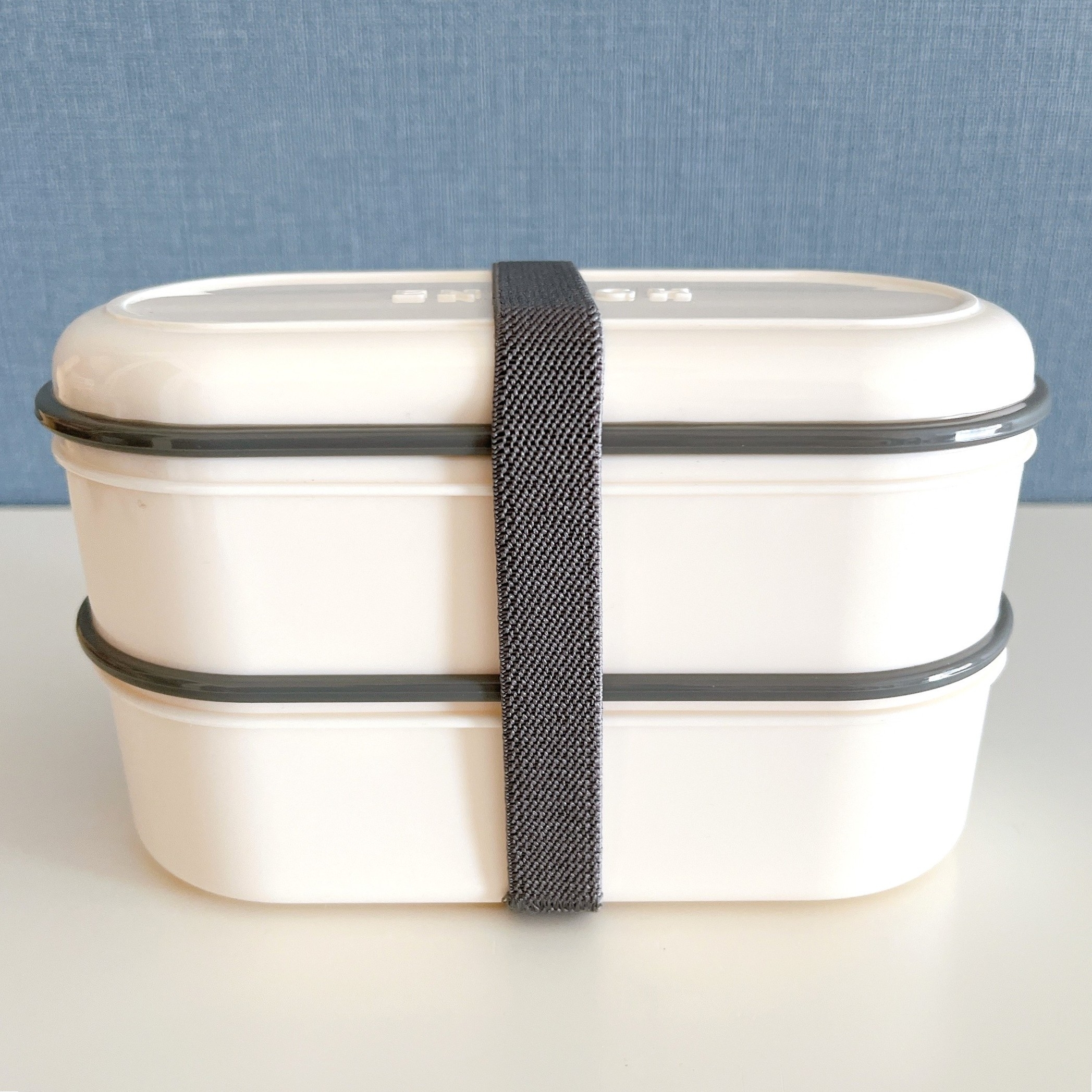 2段の弁当箱がテーブルに置かれている。ベルトで固定されている。