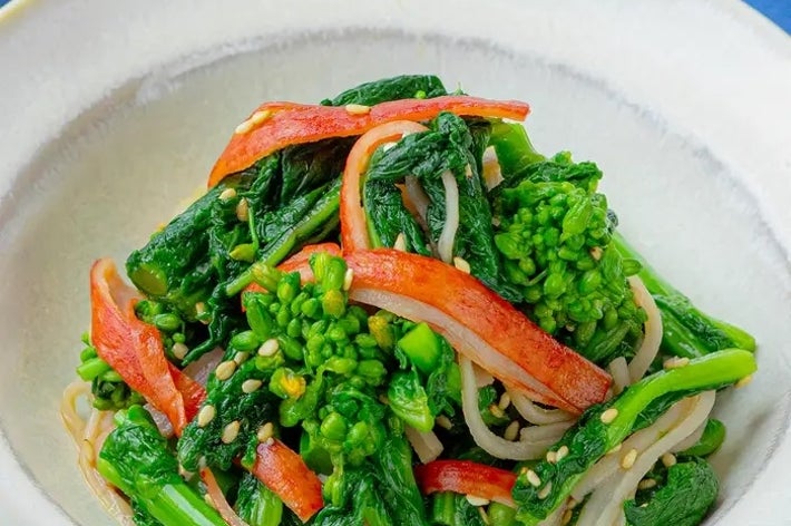 ボウルに盛られた、おひたし風の野菜料理。ほうれん草、小松菜、カニ風味かまぼこ、胡麻が含まれる。