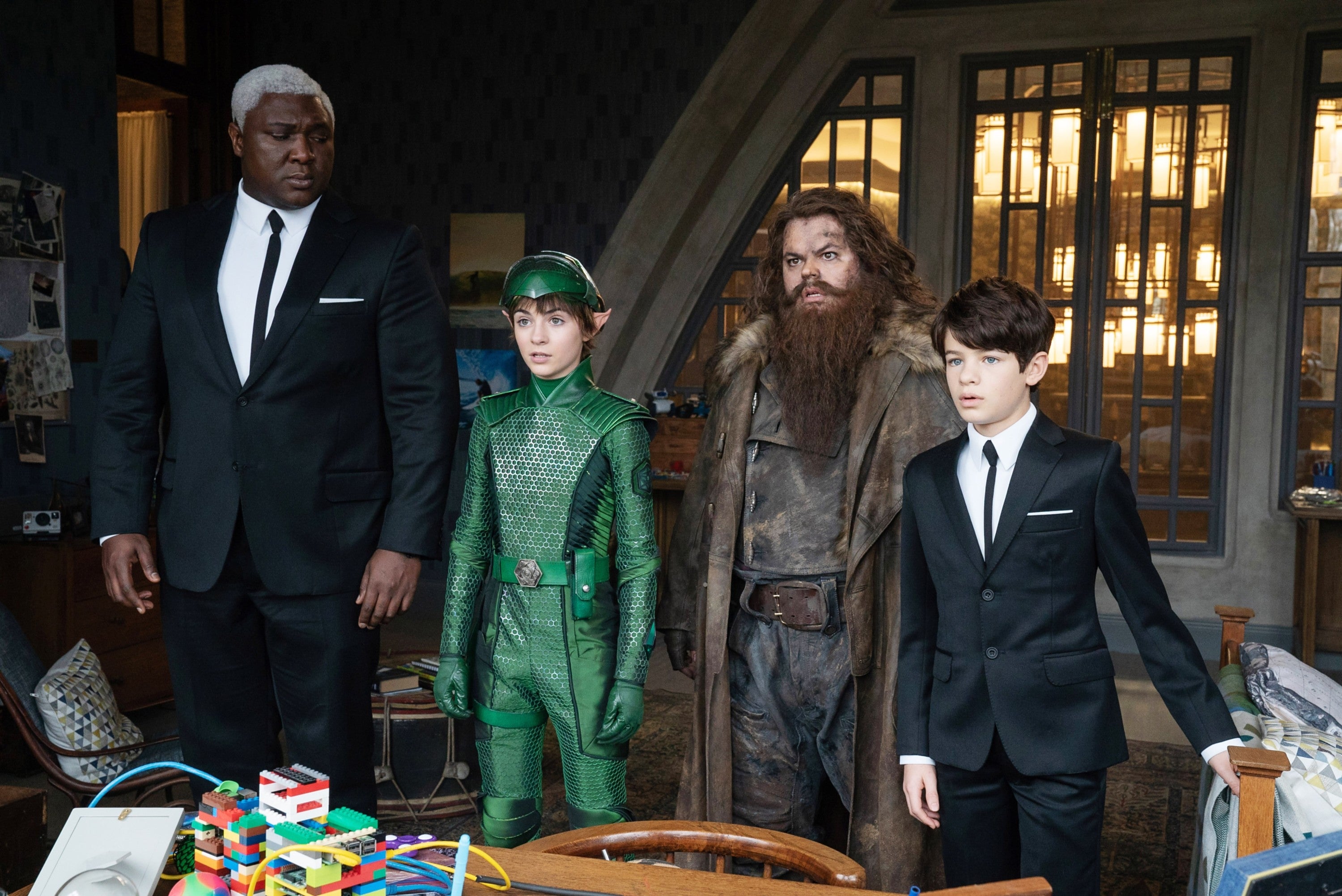 Cast of "Artemis Fowl" stood together behind a table