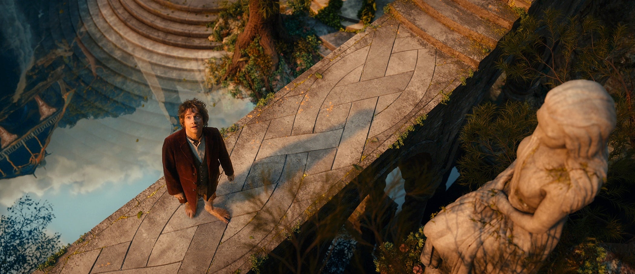 Martin Freeman as Bilbo Baggins in "The Hobbit" on a bridge looking up at the camera