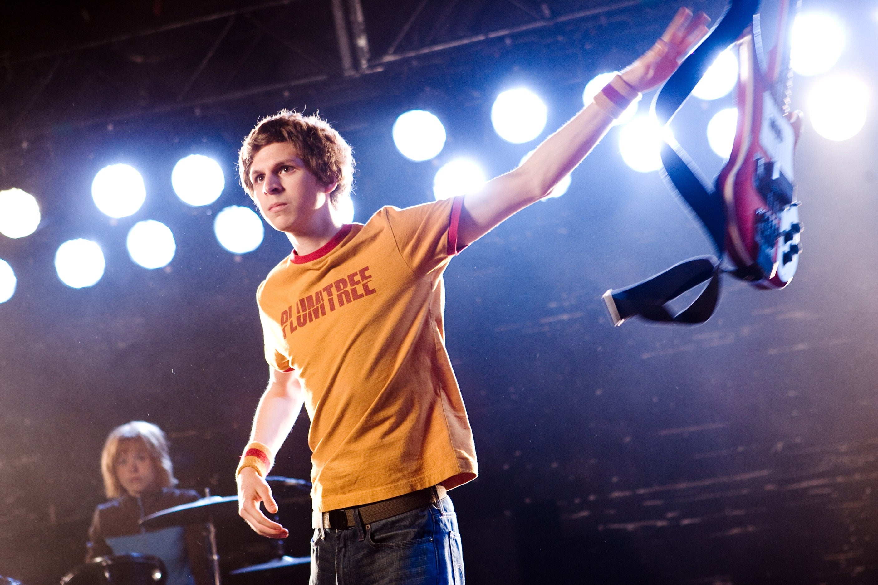 Michael Cera as Scott Pilgrim in "Scott Pilgrim Vs. The World" onstage holding a guitar away from him