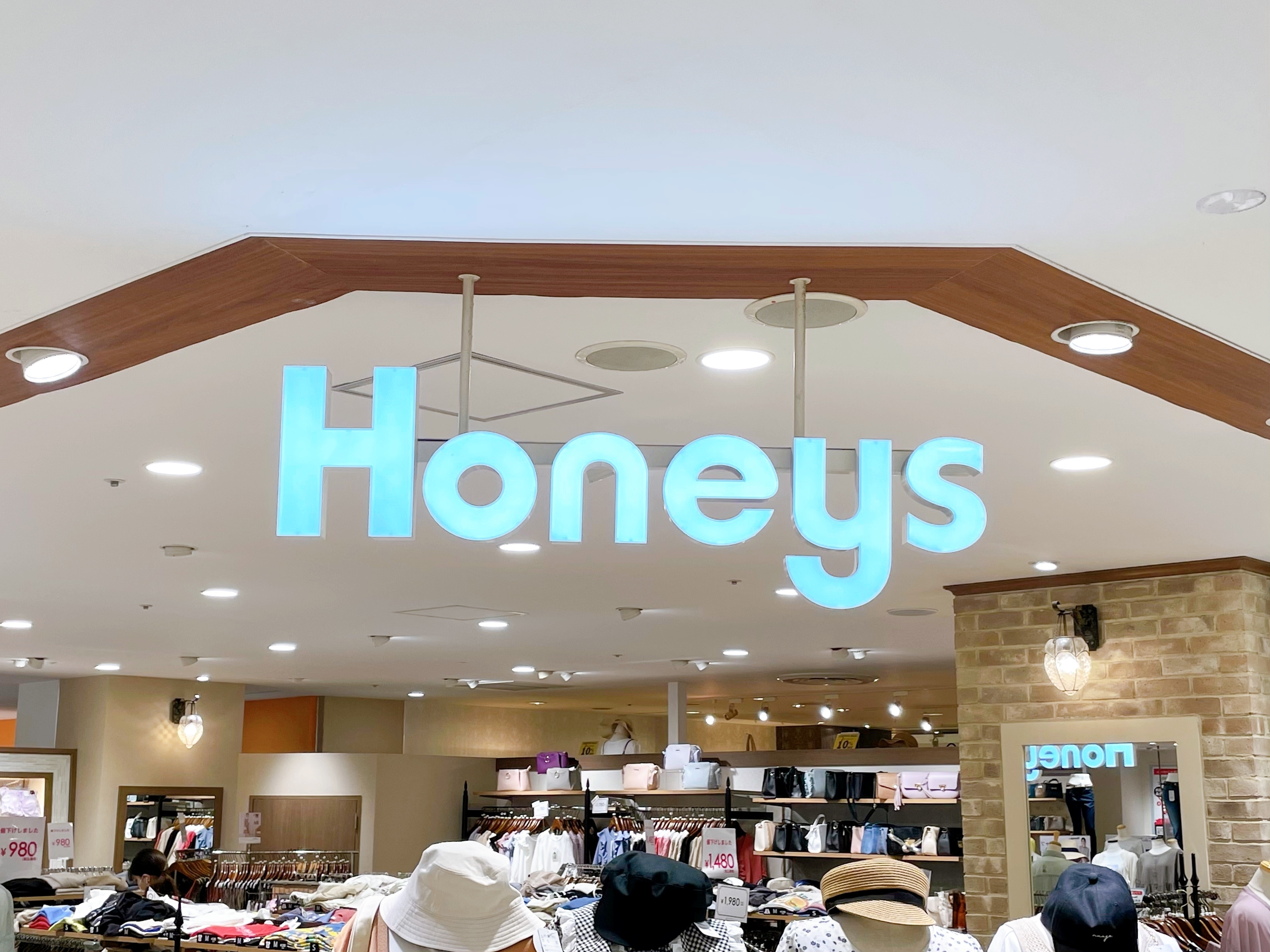 店名「HONEYS」の看板が店内上部に表示された衣料品店の様子。
