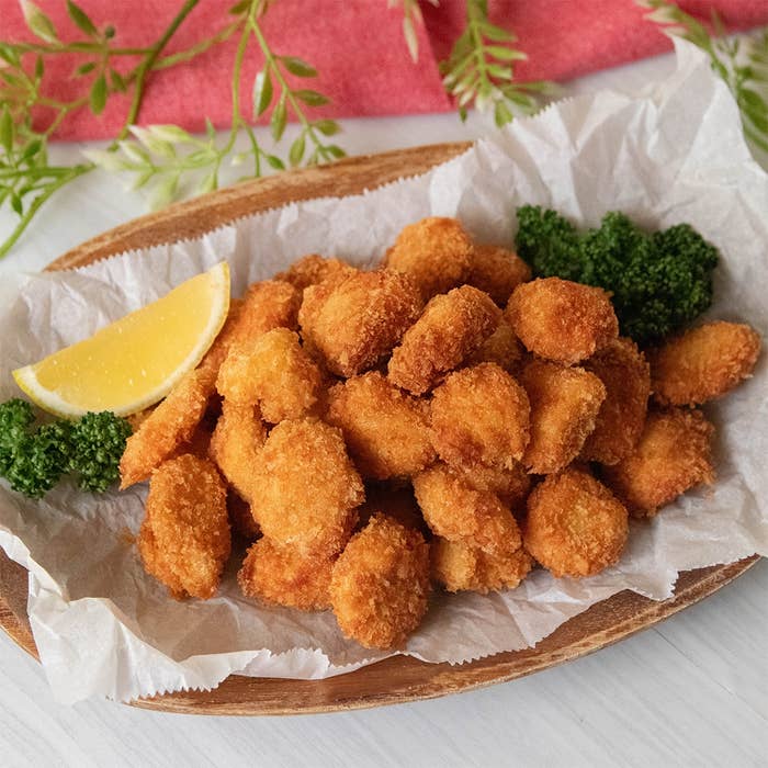 鶏ささみのポップコーンチキンが盛られた皿にレモンとパセリが添えられています。