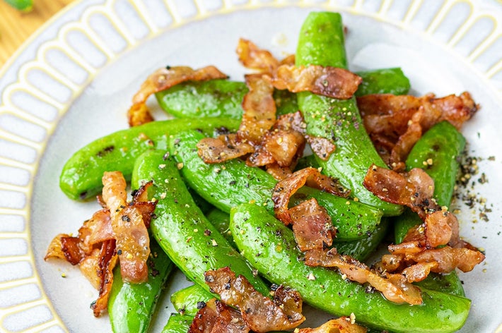 スナップエンドウとカリカリベーコンの炒め物が皿に盛られている。