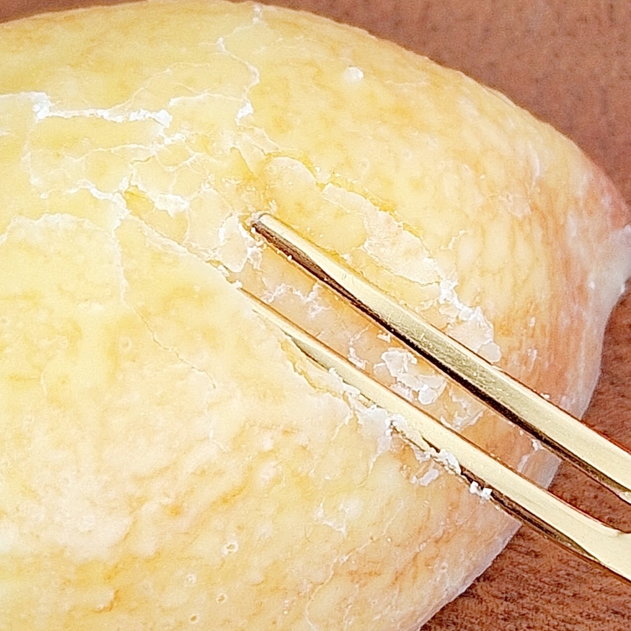 フォークでホットケーキの上を切っているクローズアップ画像。ホットケーキは表面がふっくらとしている。