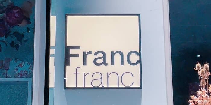 フランフランのロゴが表示されている看板。背景に花のディスプレイが少し見える。