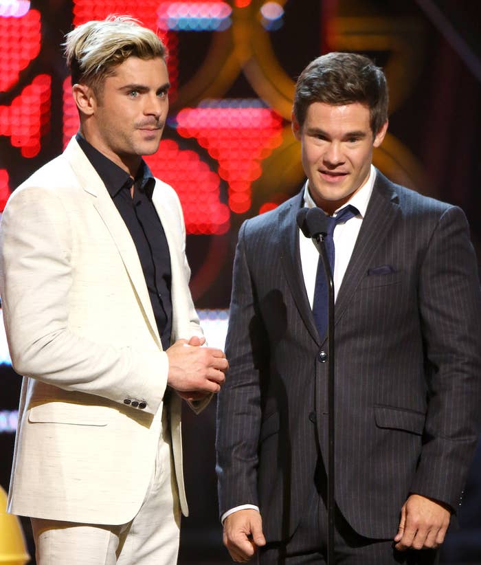 Zac Efron and Adam DeVine standing on stage at an event