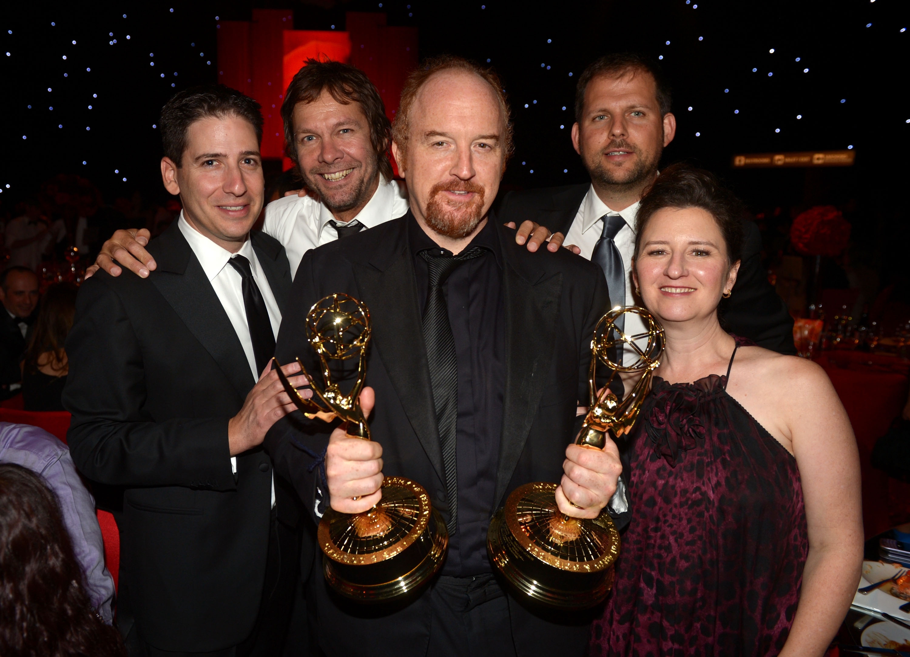 Eric Schier, Dave Becky, comedian Louis C.K., Nick Grad, and Blair Breard, with awards, one holding three trophies, posing together at an event, wearing formal attire