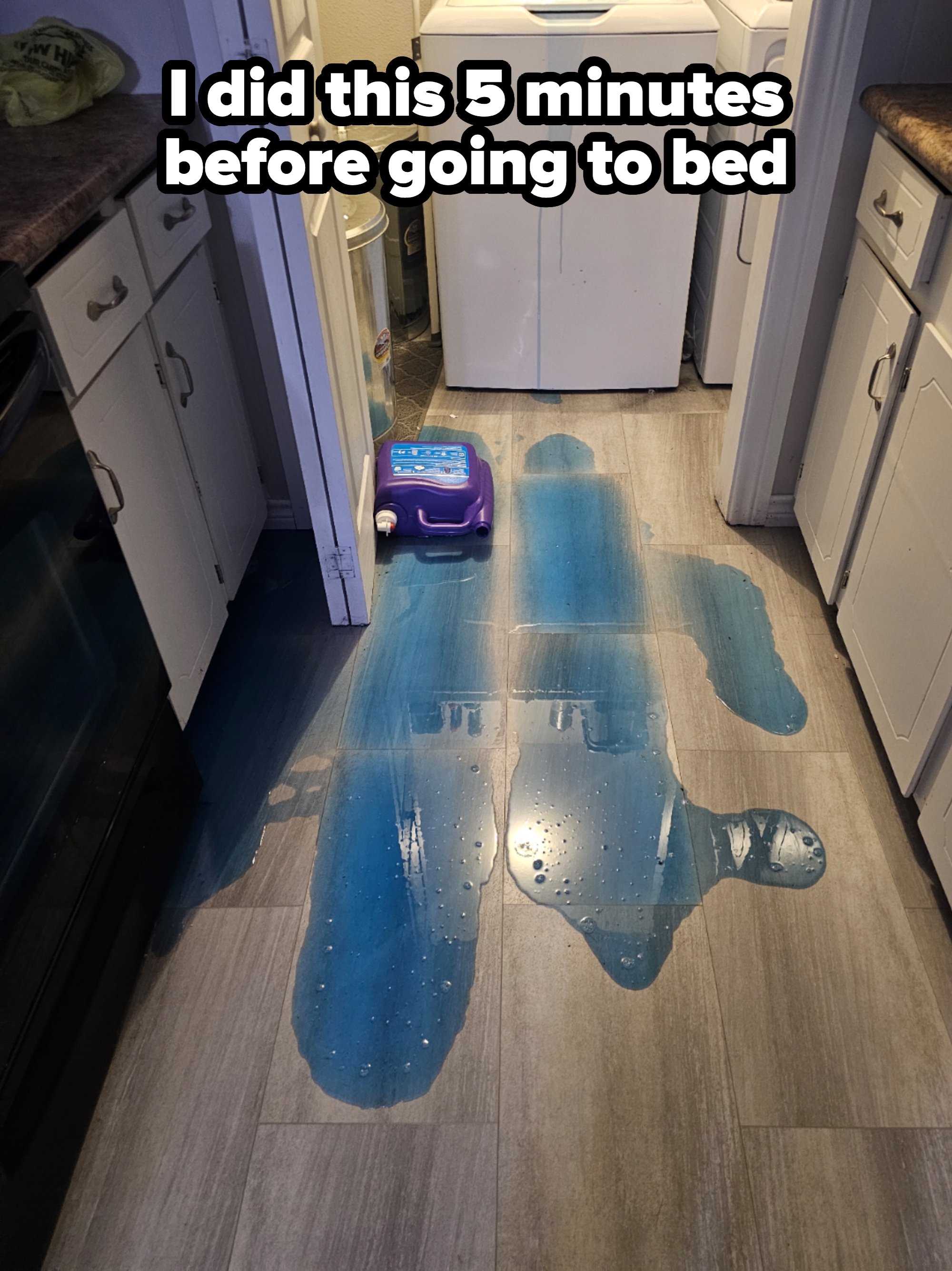 Laundry detergent spilled on a kitchen floor, creating large puddles leading from a container near a washing machine