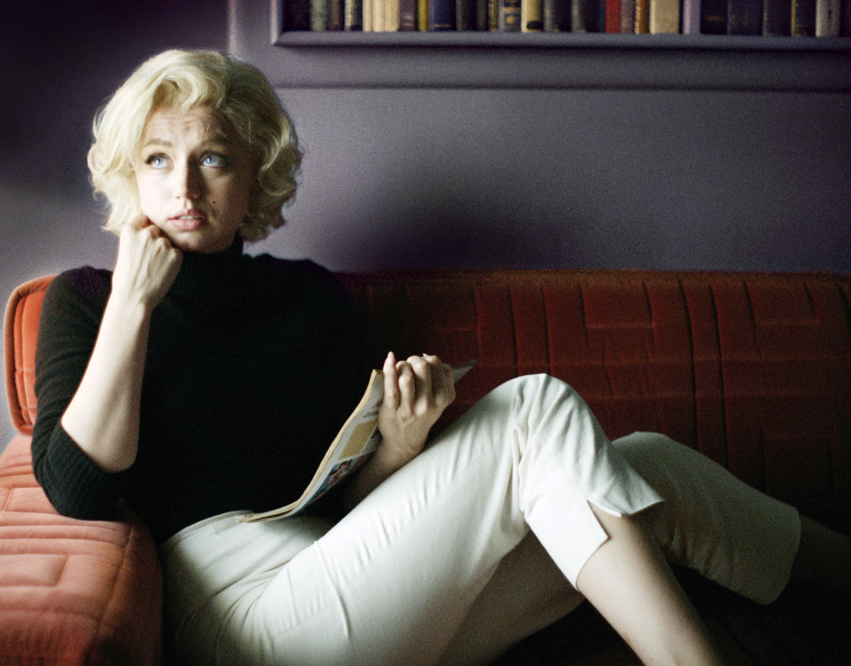 10. Ana De Armas as Marilyn Monroe in "Blonde," sat on a sofa looking up