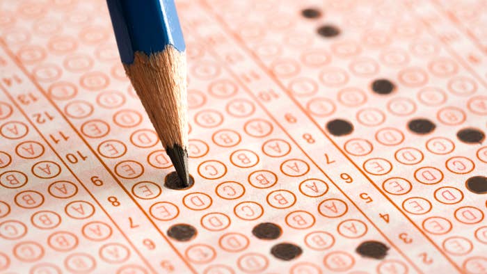 A close-up of a pencil marking answers on a standardized test sheet filled with bubbles, highlighting test-taking or exam preparation