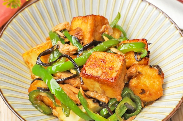 焼き豆腐とピーマンが調理された美味しそうな料理が皿に盛られている。