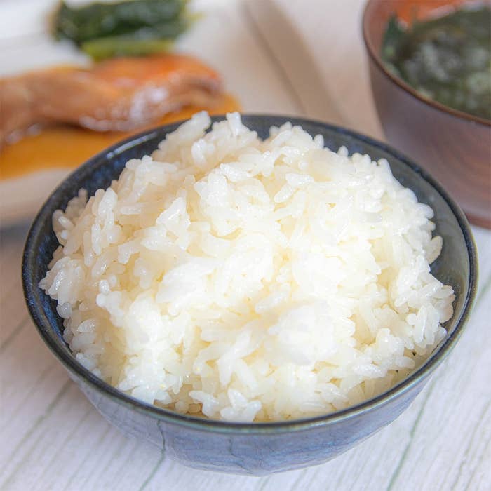 ご飯の盛られたボウルと、魚や味噌汁が並ぶ朝食セット。