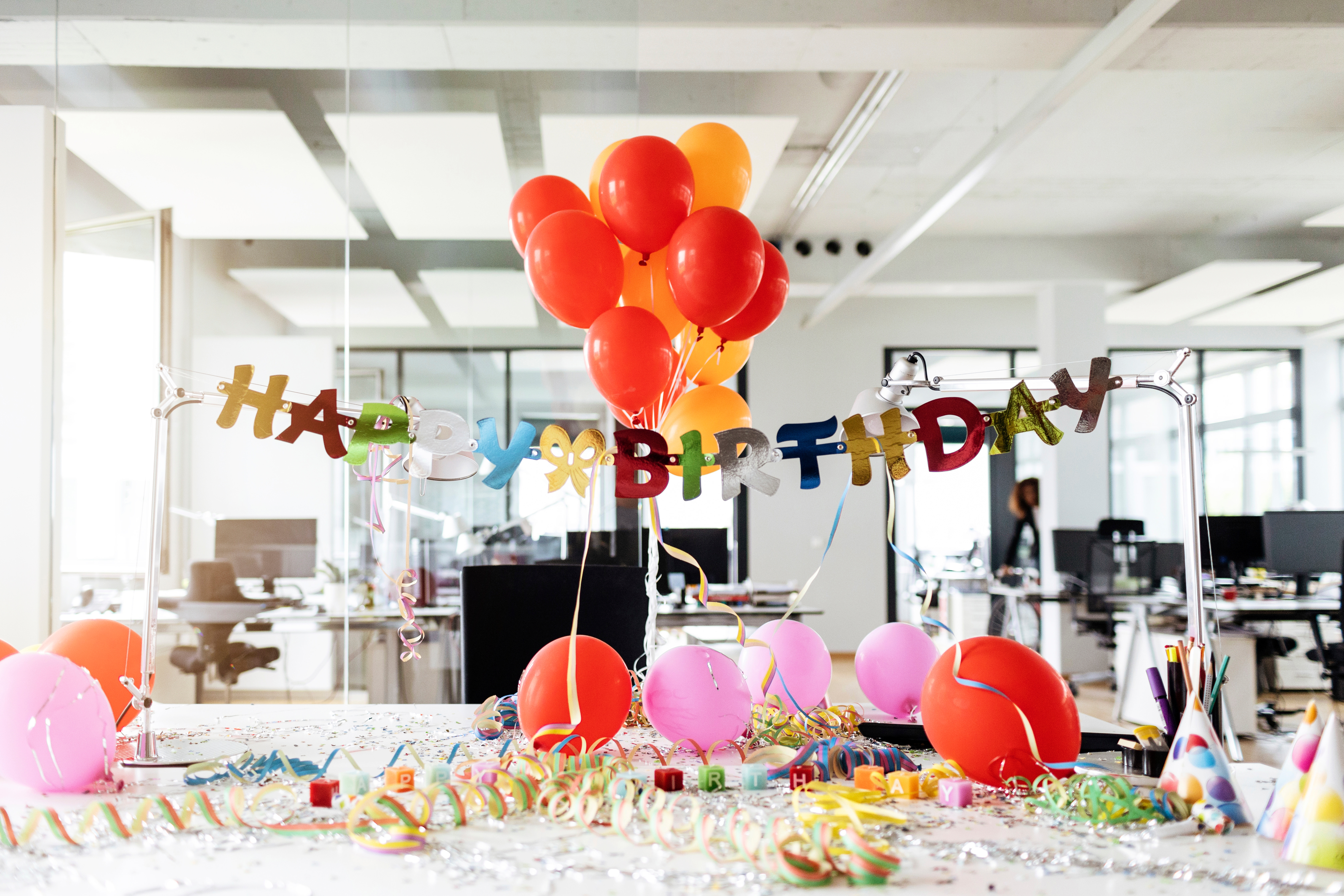 Office party for a birthday with various colorful decorations.