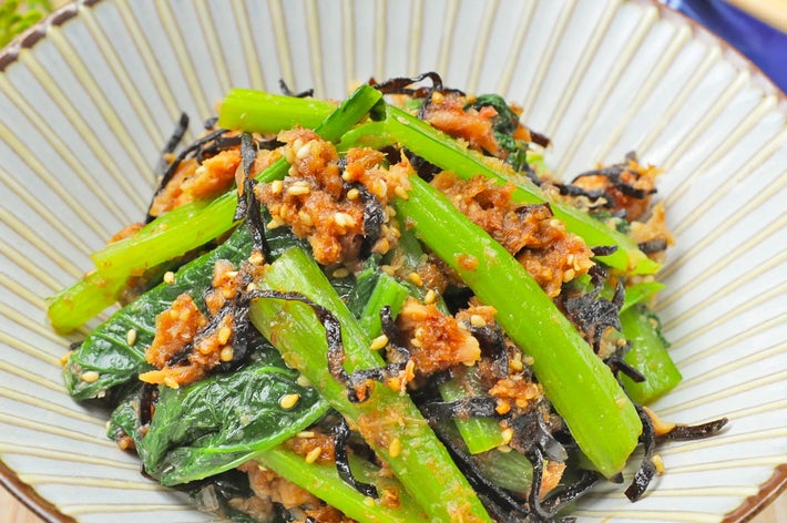 皿に盛られた鮮やかな緑の野菜とひじきの和え物。食事用に準備されています。
