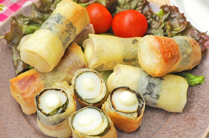 数種類の春巻きが皿に盛り付けられており、トマトとレタスが添えられています。