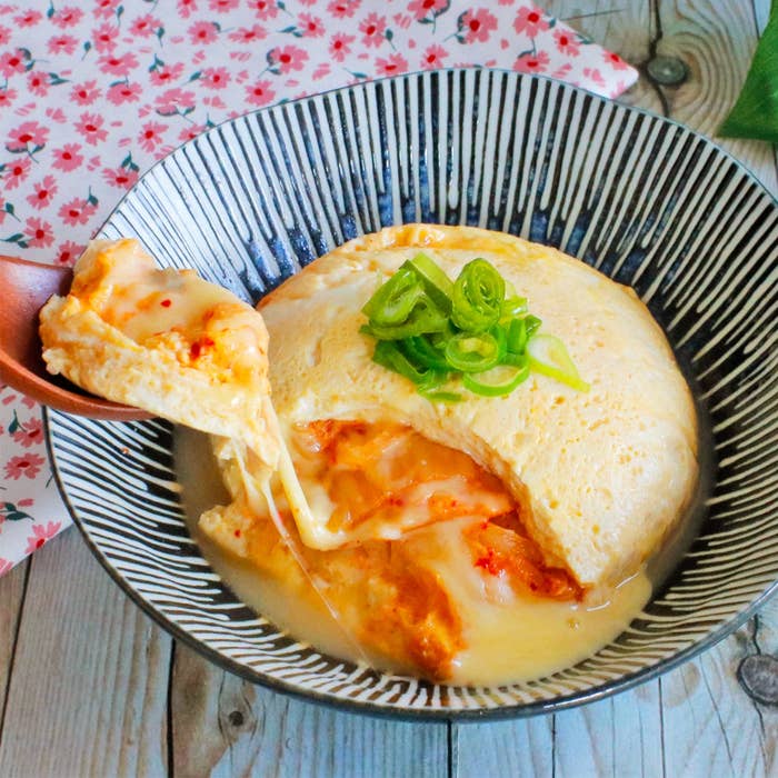 器に入ったチーズたっぷりのオムレツ。刻みネギが上に乗っている。