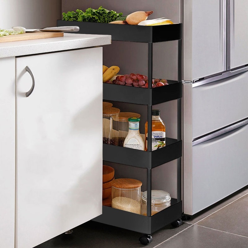 Slim rolling kitchen cart with shelves holds fruit, vegetables, and pantry items, fitting snugly between a countertop and refrigerator