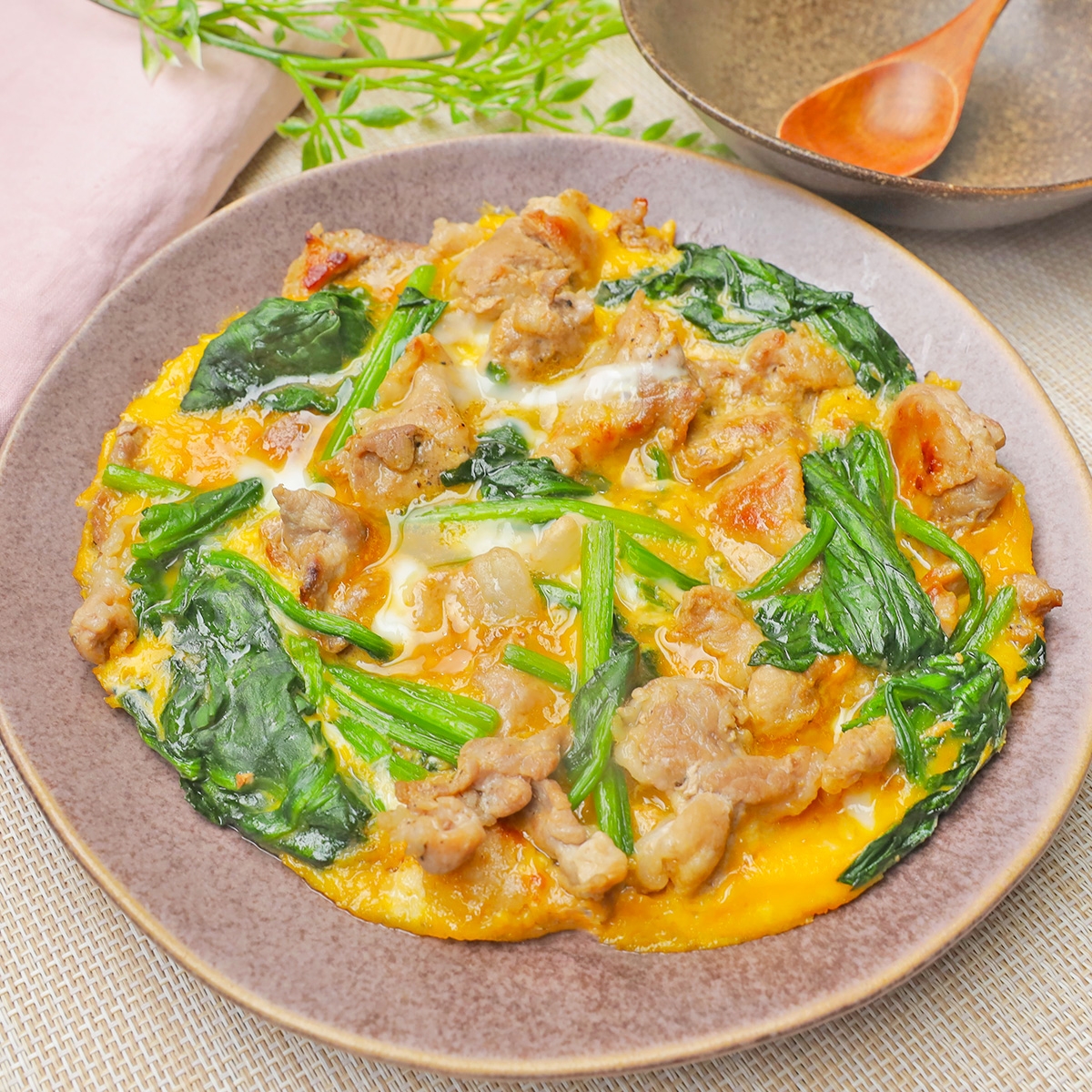 豚肉とほうれん草の入ったオムレツが皿に盛られている、美味しそうな料理。