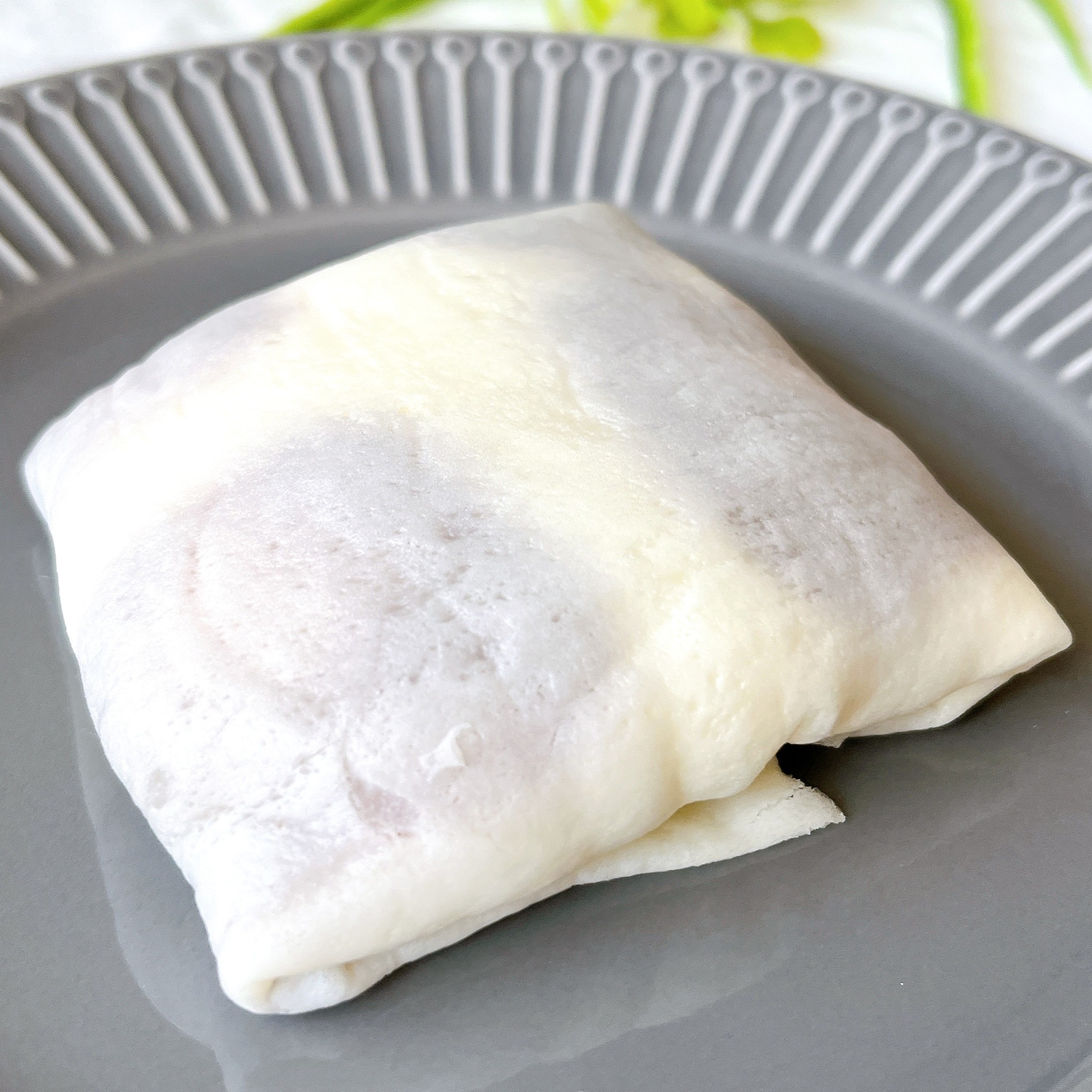 皿の上に置かれた四角い形の薄い生地で包まれた食べ物。