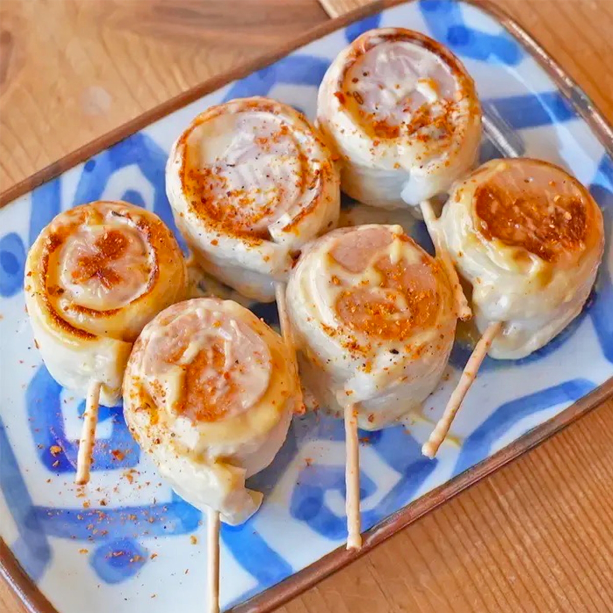 お皿に盛り付けられた串刺しロール。青と白の模様がある皿。