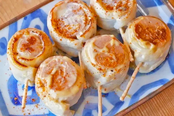 串焼きにされた餃子が皿に盛られている。美味しそうな焼き目がついている。