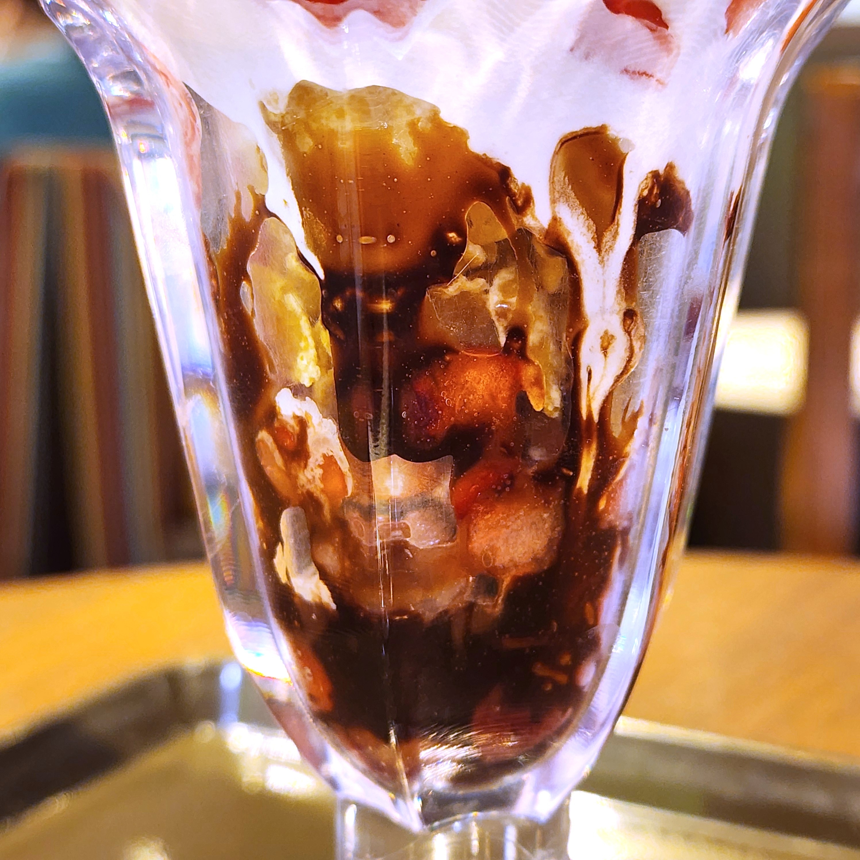 パフェグラスに盛られたチョコレートソースとその他のシロップの豊かで複雑な模様。