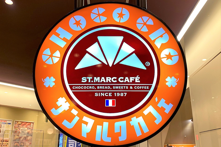 サンマルクカフェの看板。チョコクロとコーヒーを提供し、1987年創業と記載されています。フランス国旗のマークがあります。