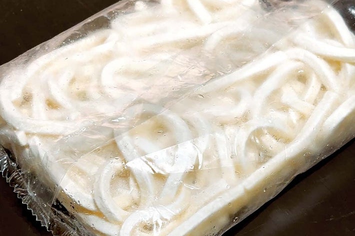 冷凍されたうどんのパック。包装が施された状態で置かれている。