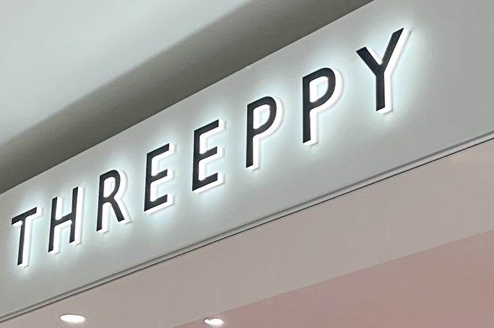 店舗の看板に「THREEPPY」と表示されている。シンプルなデザインの店構え。