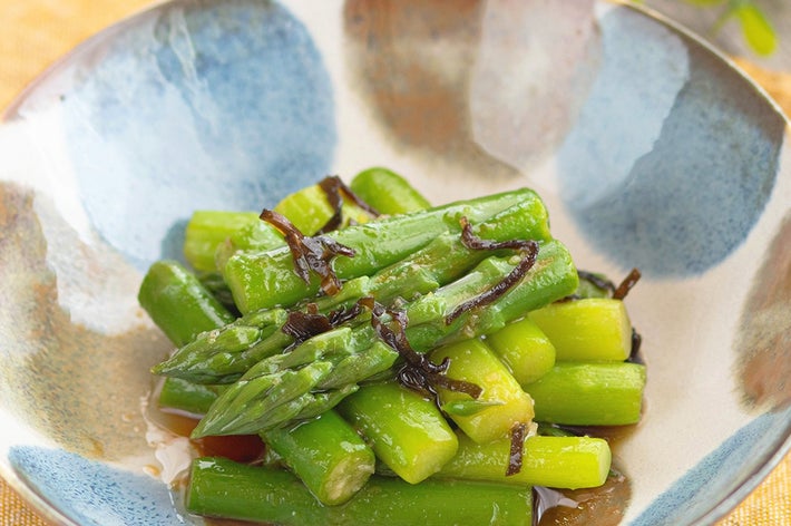 アスパラガスと昆布が入った皿の和風サラダ。