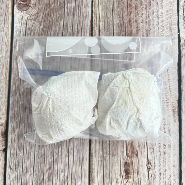 ジップロック袋に入れられた2つの包み物が木製の背景に置かれている。