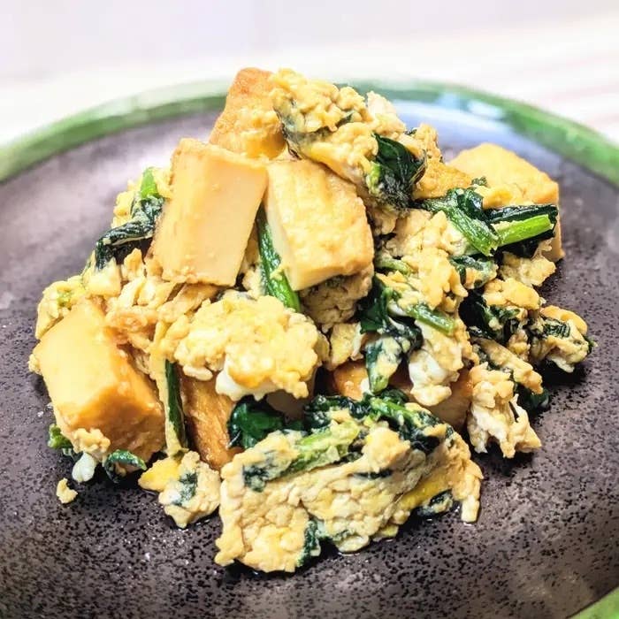 豆腐とほうれん草の炒め物の料理が皿に盛られています。