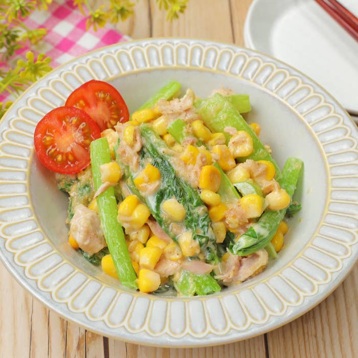 コーンを使ったクリーミーなサラダが皿に盛られている。テーブル上に箸も置かれている。