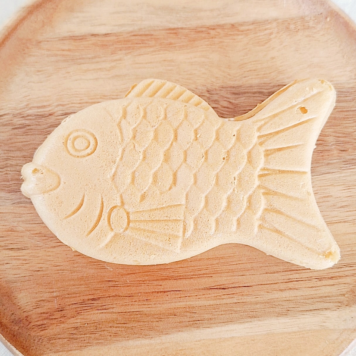 木製ボードの上に魚の形をしたたい焼きが置かれています。