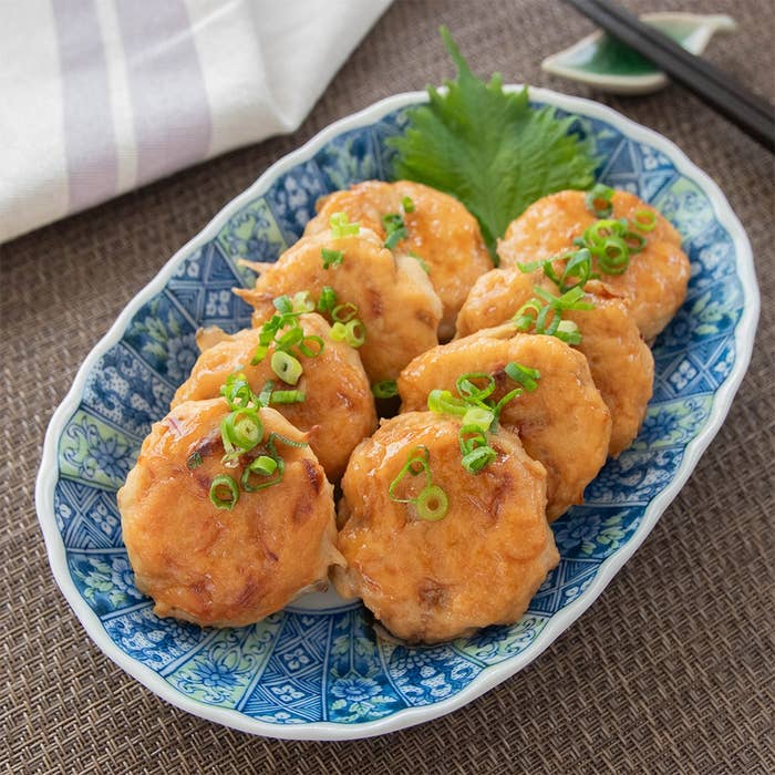 皿に盛られたごぼう入り鶏つくね。ねぎがトッピングされ、美味しそうに並んでいる。