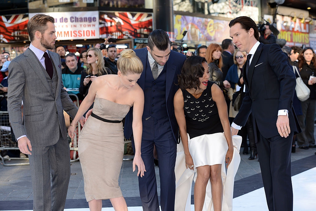 surrouned by her costars, Zoe reacts as her skirt is blown by the wind