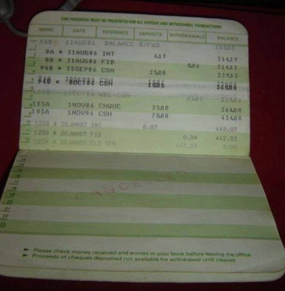 An open bank passbook displaying transaction details, including dates, withdrawals, deposits, and balances