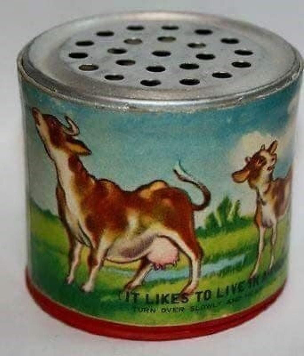 A vintage novelty can with illustrations of cows and a perforated lid, labeled, "It likes to live in a can. Turn over slowly and see."