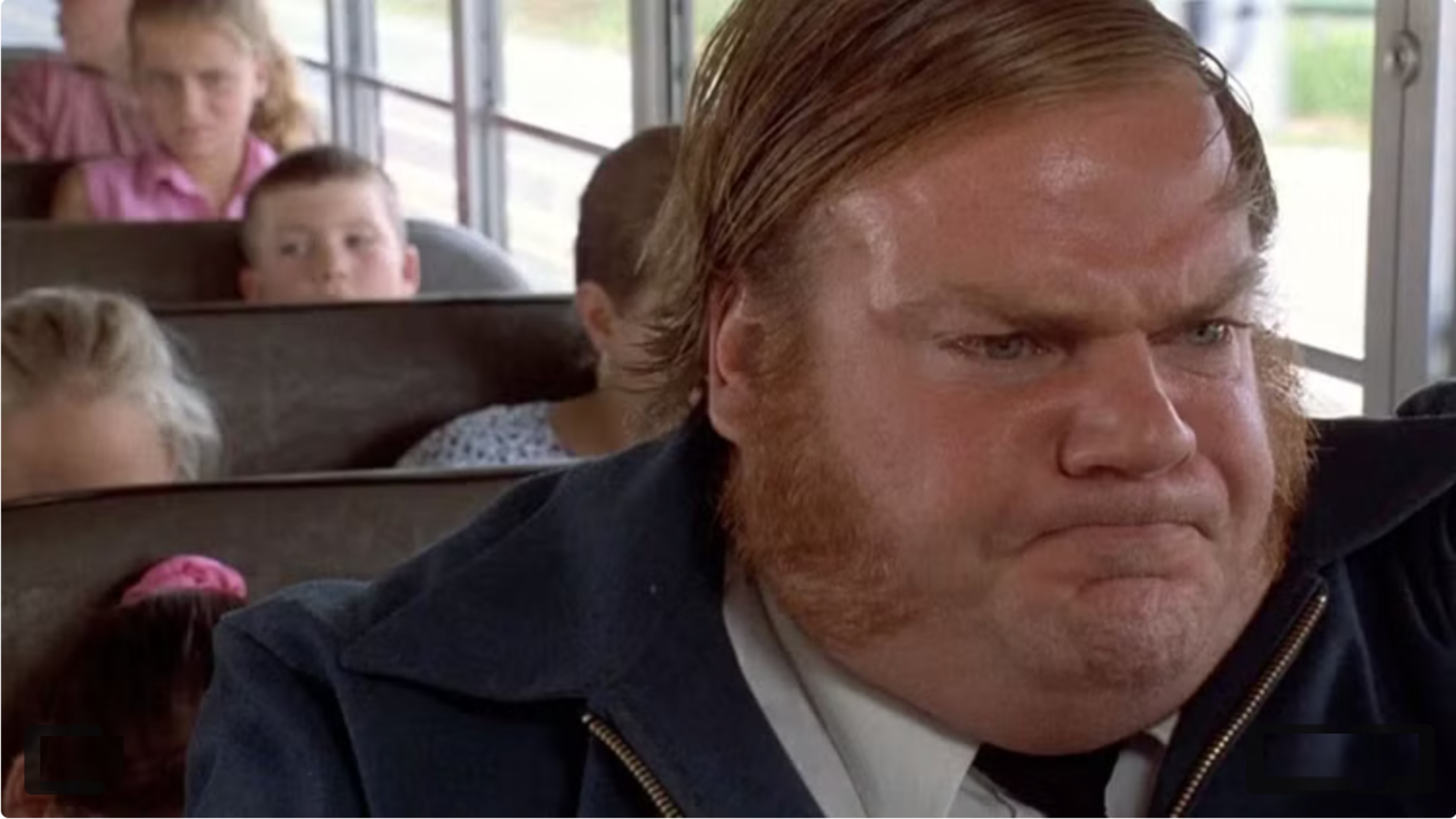 Person with sideburns and determined expression sits on a bus. Passengers, including children, are visible in the background