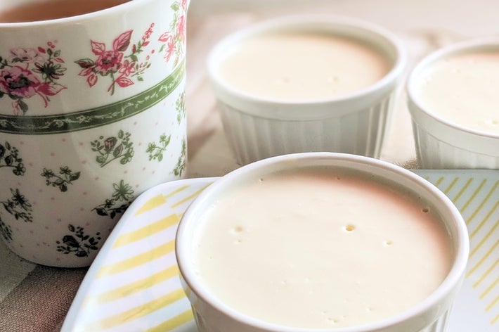 カップに入ったプリン3つと花柄のティーカップがテーブルに並んでいる。