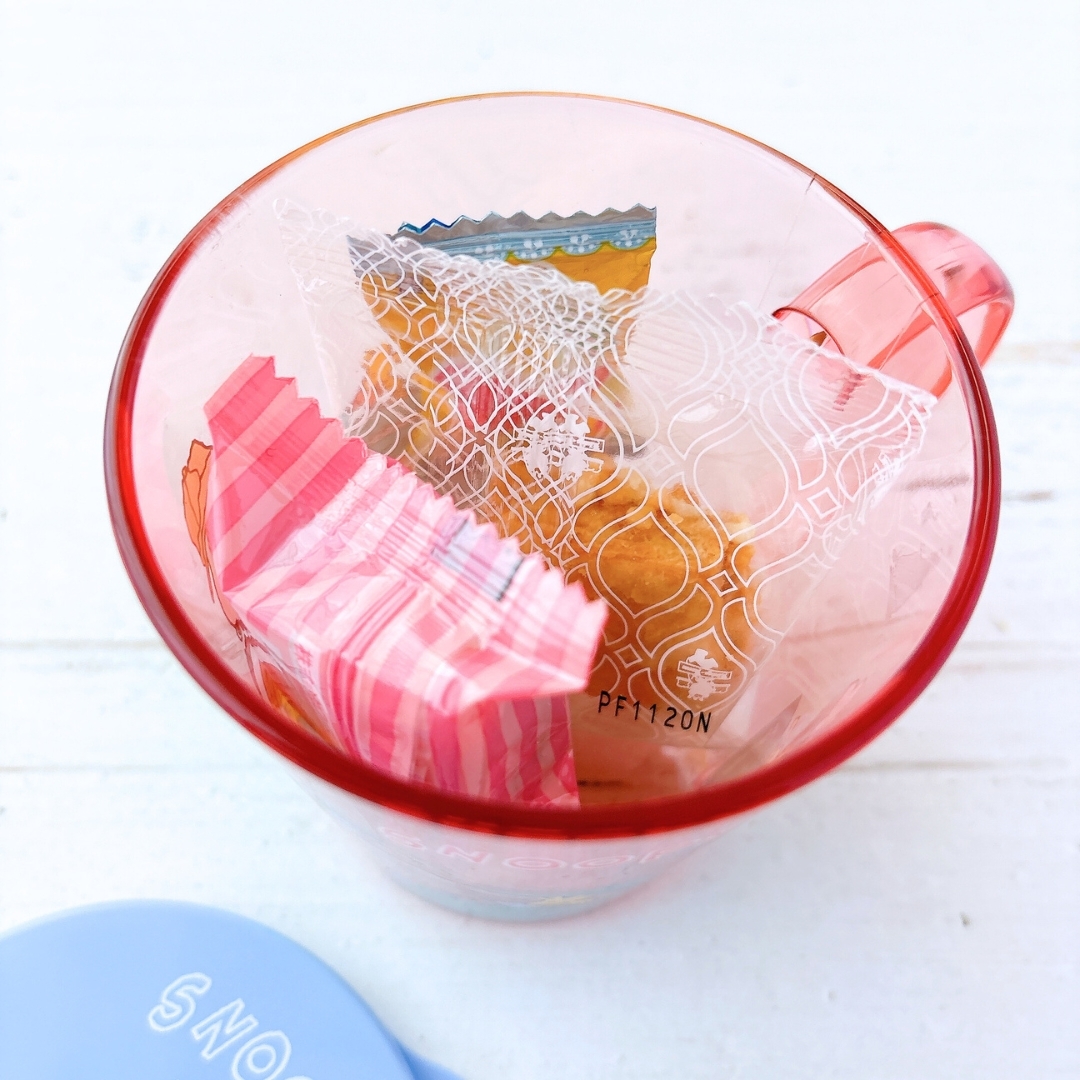 赤いカップに入った2つの個別包装のスイーツ。包装はストライプ柄と模様入り。