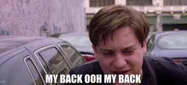 A man crouches by a car, holding his back in apparent pain. Text: "MY BACK OOH MY BACK."