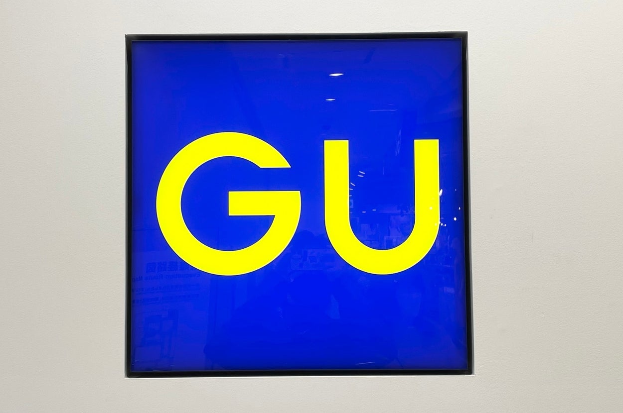 Sign with the letters "GU" prominently displayed