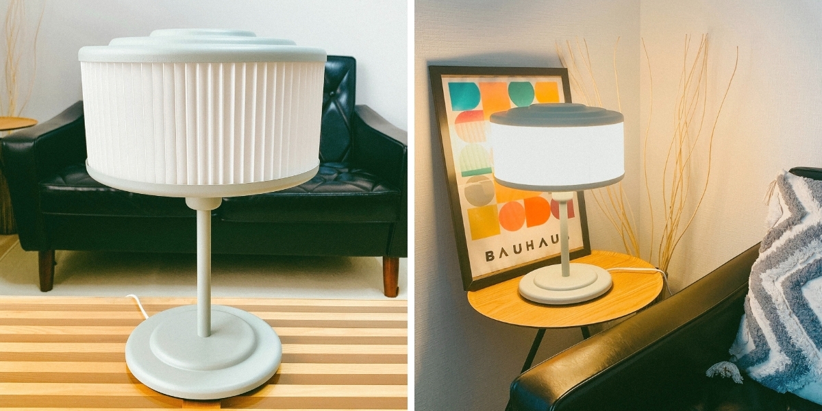 左: 黒いソファとストライプのテーブル上のモダンなランプ。右: 小さなサイドテーブル上の同じランプと壁アート。