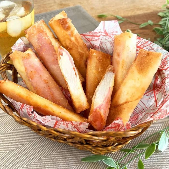 カゴに盛られたチーズとハムを巻いたスナック食品。サクサクの外観で、美味しそうに見える。