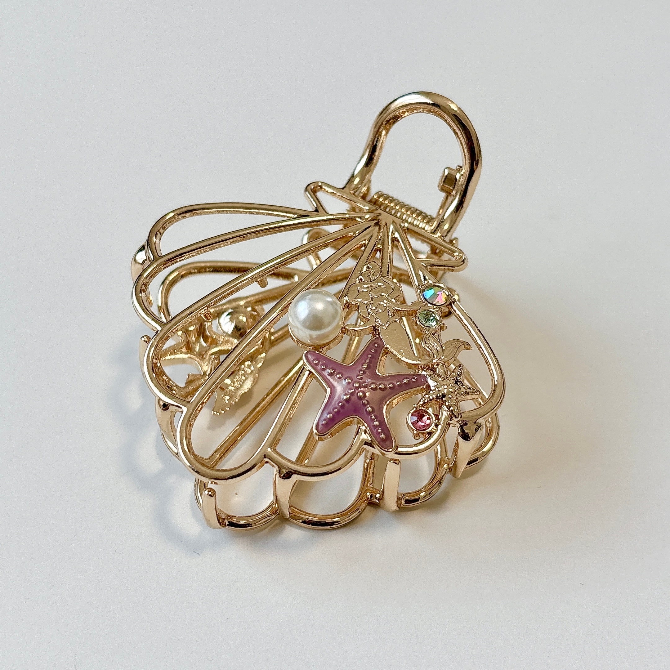 金色のシェル型ヘアクリップに、パールと海のモチーフ装飾。